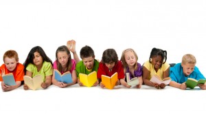 A group of diverse children reading a book.